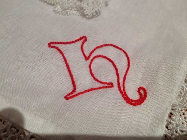 Stem stitch monogram for King Henri that I embroidered onto a linen handkerchief I hemmed and added pre-made cotton lace to as a gift from the Barony of Politarchopolis to Their Majesties when they visited Fields of Gold.
