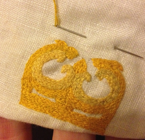 Partly finished firestriker badge (it's missing the steel and flames). Silk thread split-stitch on a linen base.