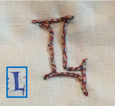The L embroidered in stem stitch by Ceara, with the Bible of Puiset letter font it was based on to the left in the small box.