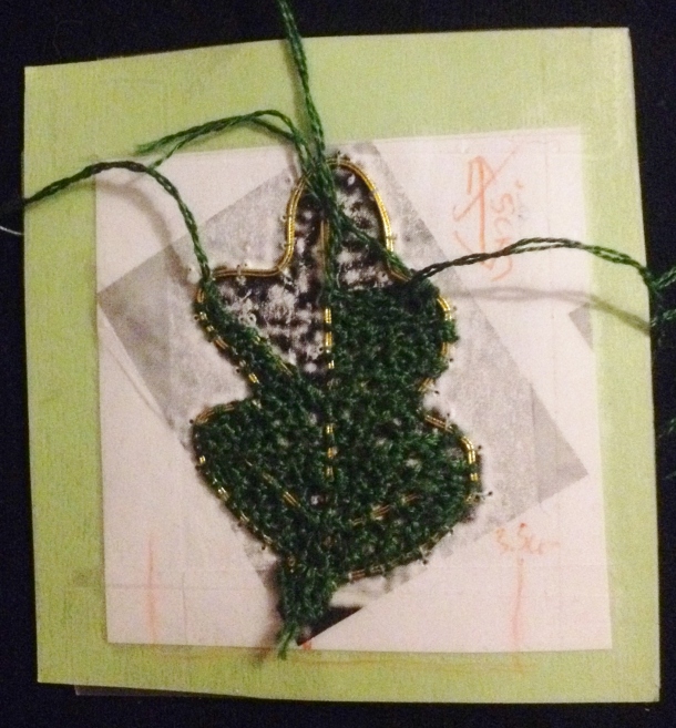 Tassel attempt 2: the leaf shape is filled in with detached buttonhole stitch in green silk.