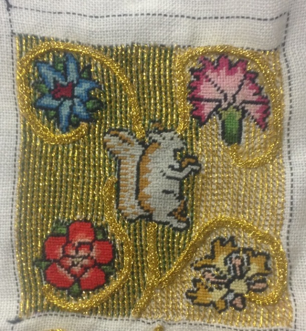 As you can see, on the left, the coils stand out more once the green silk backstitch is applied. Furthermore, the backstitch fills in most of the gaps between the columns of tramming.