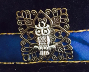 Figure 17: Close up of the owl and filigree square couched to the hat band.