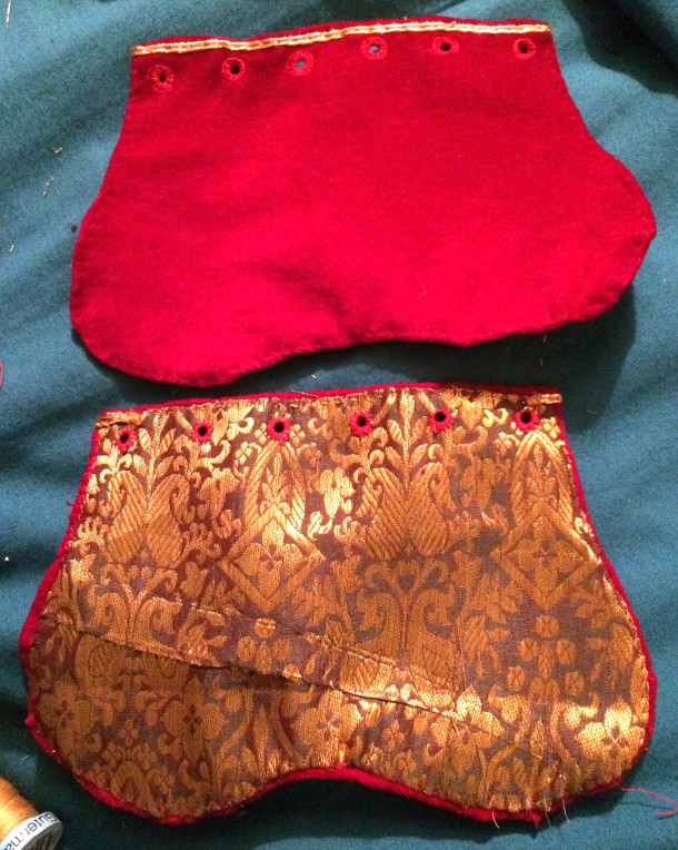 The two pouches front (top) and back (bottom) with gold couching and eyelets. Photo and work by Ceara Shionnach, 2015.