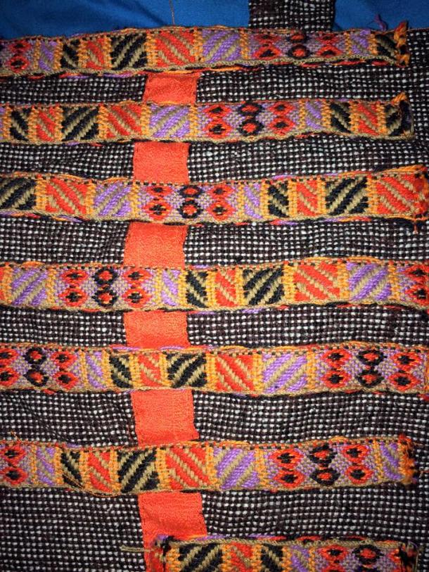 A close up of the braid (horizontal stripes) and the silk (vertical stripe along seam). Photo by Ceara Shionnach, April 2015.