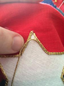 Pull the gold cord gently through the hole. Then, repeat with the second gold cord tail.
